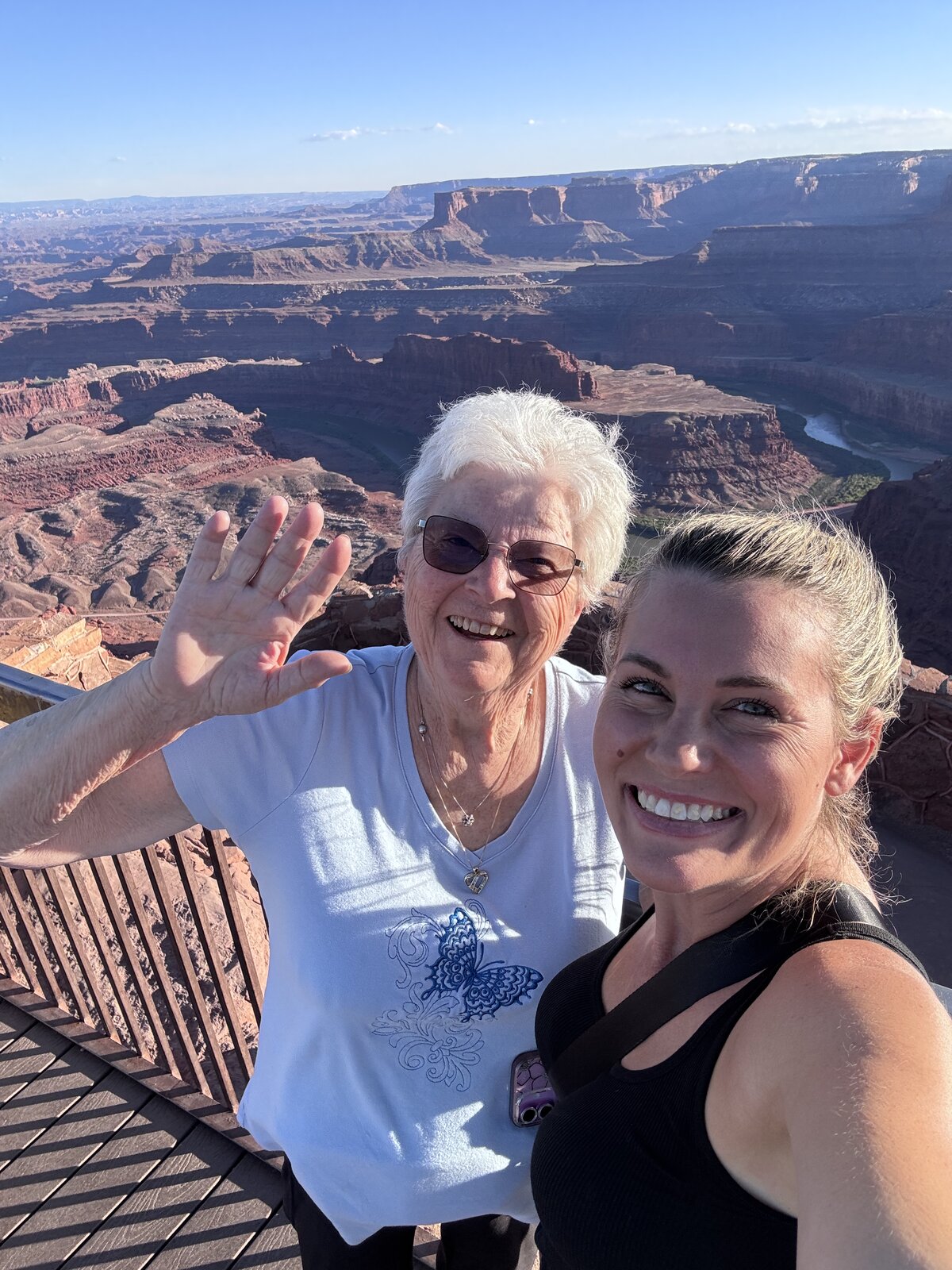 Grandmother and granddaughter smiling at a red rock canyon overlook in Utah at golden hour